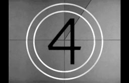 An old film reel countdown, the number four is centred in the frame with 2 white concentric circles around it.
