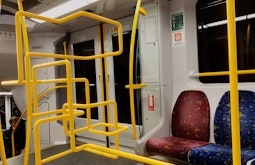 A digitally imposed yellow stainless steel bar winds its way around inside a train carriage.