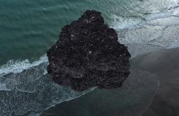 A crystal formation is super-imposed onto a birds eye view of the sea.