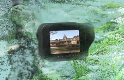 A digitally rendered camera showing a temple floats amongst a digital map of a landscape.