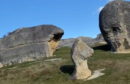 Large rock formations protrude from a grassy hill.