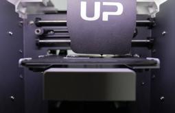 A 3D printer begins printing with white filament.