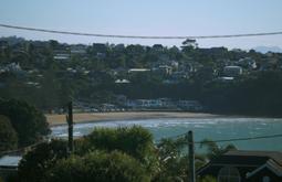 A beach surrounded by densely populated hills.