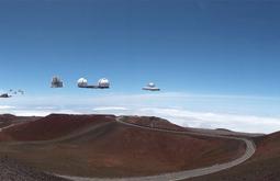 A digitally manipulated landscape in which space observatories float above the hills.