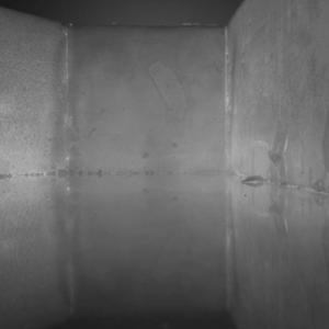 A black and white image of walls surrounding a glassy surface.