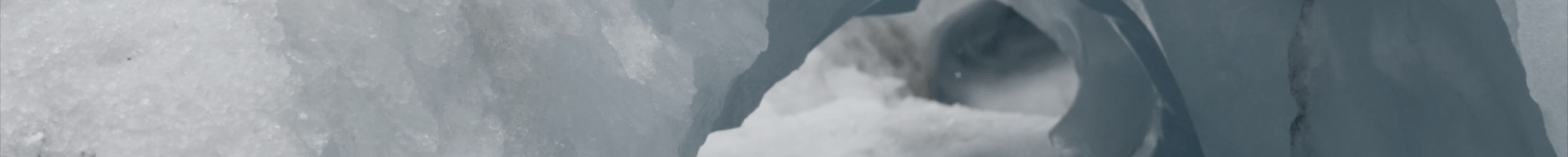 A white and pale blue ice cave holds fragments of dirt and smooth heavy ice.