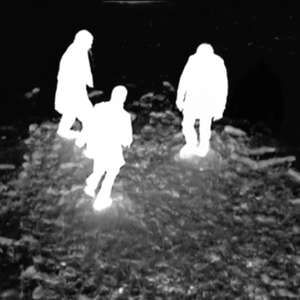 An inverted image shows three bright white figures moving about on a dark black landscapes