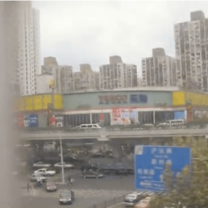 A pixelated image of a cluster of high rise shanghai apartments taken from a train