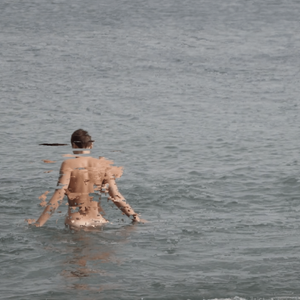 A naked body glitches whilst entering a grey sea