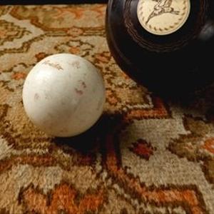 A magic 8-ball and a white pool ball sit on 70s patterned carpet