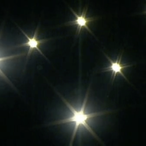 7 bright lights create star shapes in the dark sky