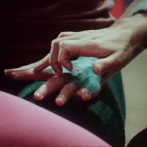 A hand covered with a wet bandage is caressed