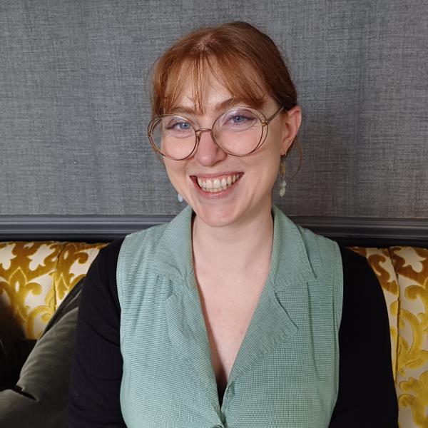 A woman with glasses smiles for the camera.