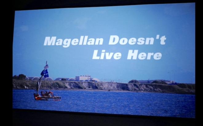 A screen showing people on a boat on the sea with large text reading "Magellan Doesn't Live Here"