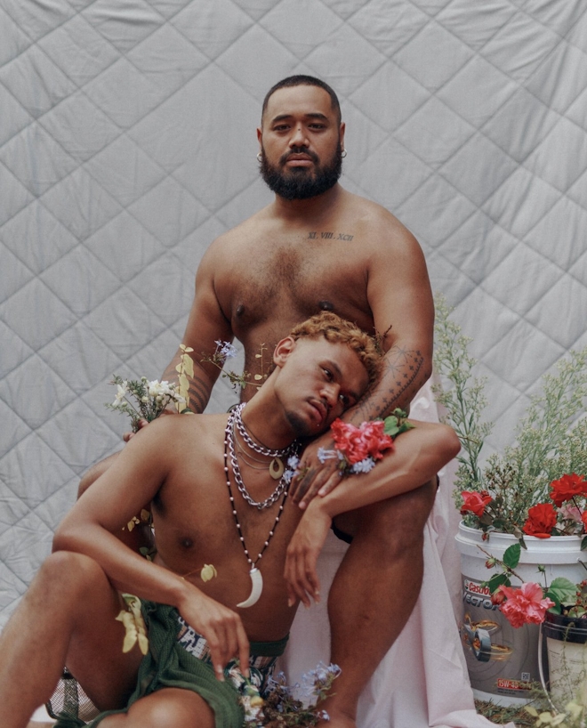 Two beautiful queer brown people embrace tenderly