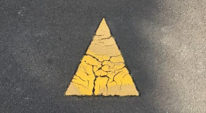 A yellow painted triangle on a road
