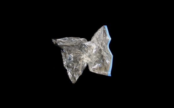 An empty silver wine bladder contracts into a star-like shape as if the air has been sucked out of it. The background is black, which makes the wine bladder appear to float in space. An empty silver wine bladder contracts into a star-like shape as if the air has been sucked out of it. The background is black, which makes the wine bladder appear to float in space.