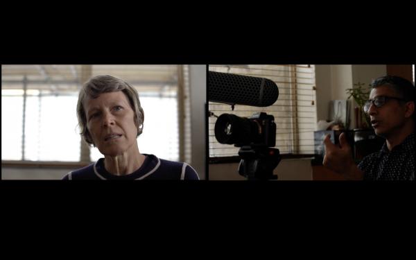 Two images placed side by side, showing, at left, an interviewee, and, at right, an interviewer. The interviewee appears to be listening while the interviewer poses a question of makes a point. The interviewers camera points towards the interviewee.