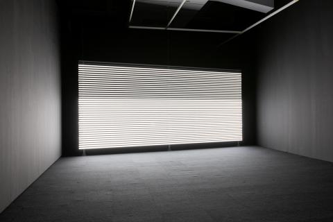 Installation view of Mariana Simnett's work 'Faint with Light' Installation view of Marianna Simnett's work 'Faint with Light', showing a wall covered in horizontal bands of white light