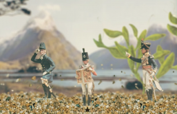 Three military model figures are standing in the stony bottom of a fish tank. A landscape is suggested by a picture of a mountain in the background, and green oxygen weed in the mid-ground.